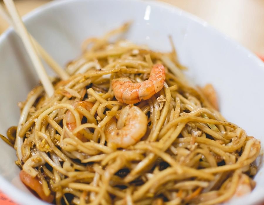 Stir fried noodles tossed with vegetables in a bowl